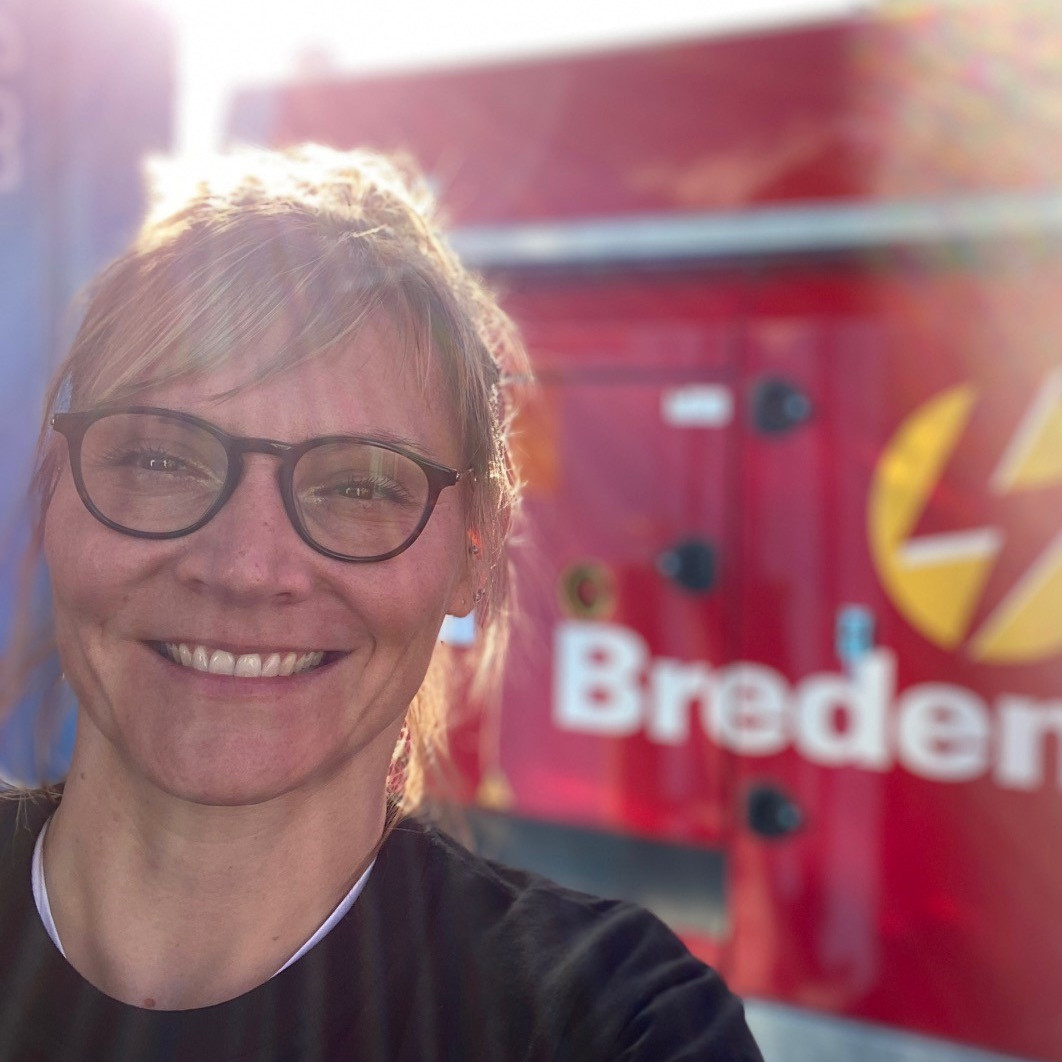 Selfie of Christin Müller, in front of a power genset